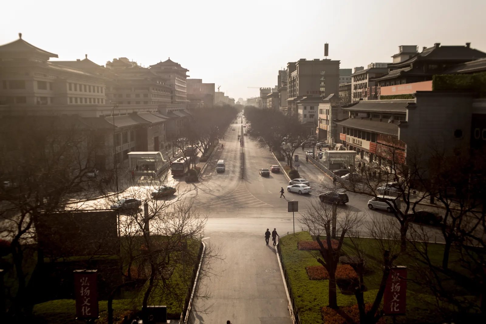 兩側樓房夾著一條寬闊街道，前景有整齊的綠地。